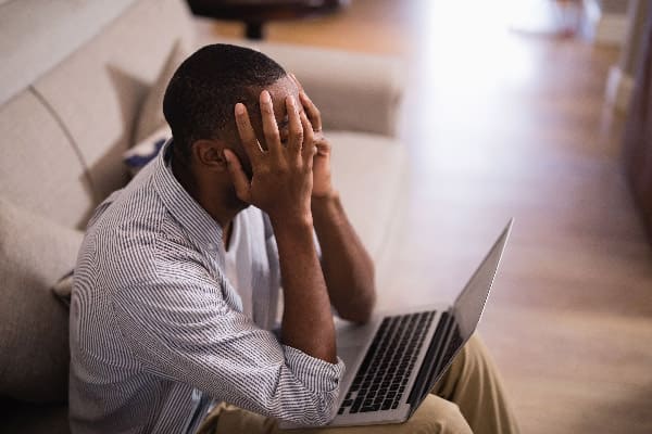 homme désespéré devant son ordinateur portable