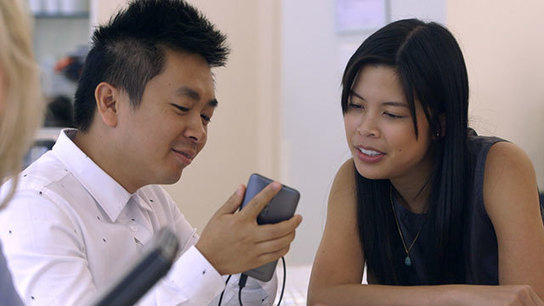 Image rerpésentant deux personnes regardant un téléphone